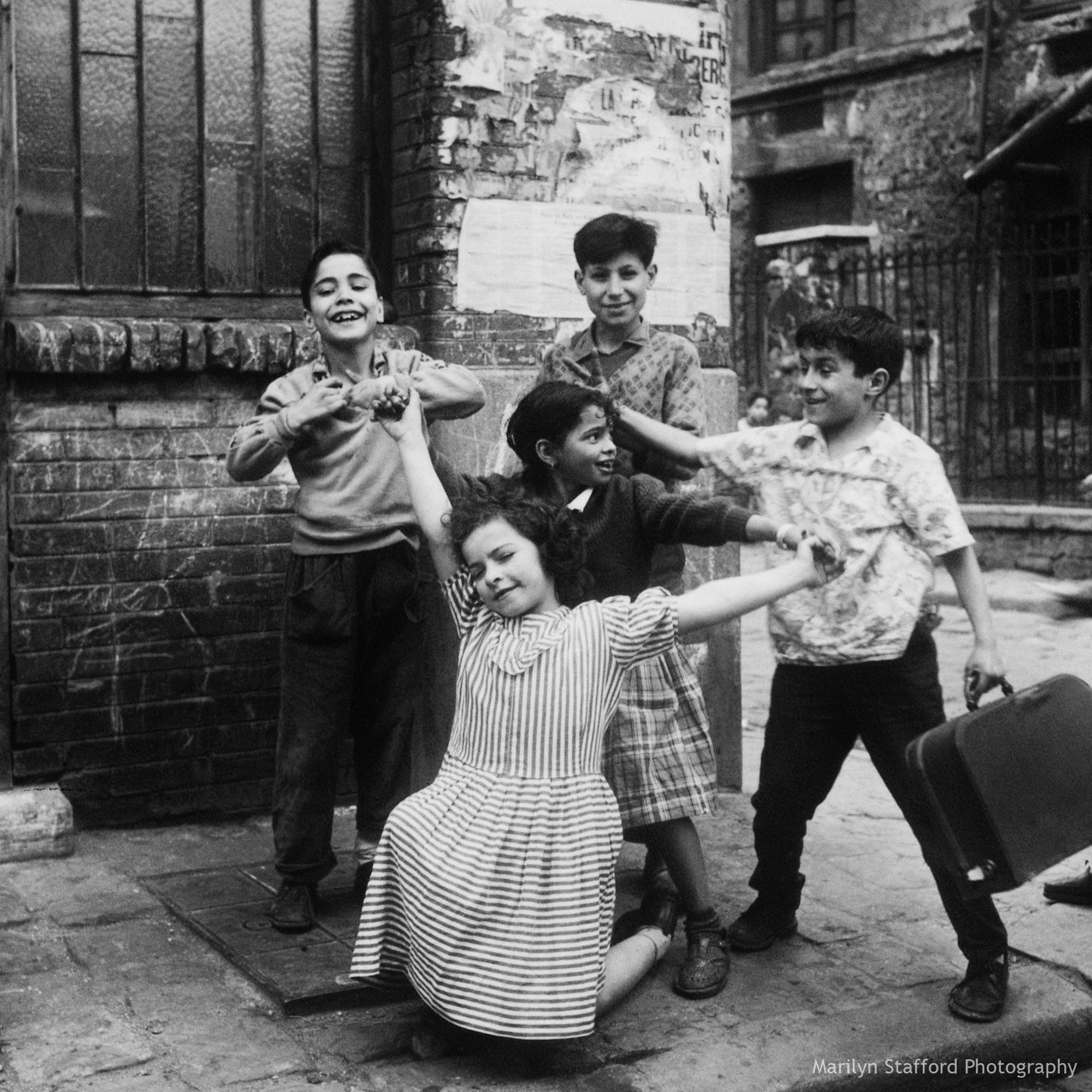 Children strike a pose, Cité Lesage-Bullourde, Paris, c1950. – Marilyn